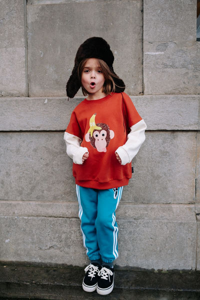 Bruine jongenssweater Funky Kong van Daily Brat met ecrukleurige mouwen en een speelse aap met banaanprint op de voorkant.