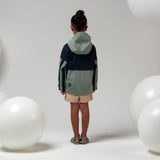 Lichtgroene uniseks regenjas 'Roaring Cat' van Gosoaky met kap en reflecterende strip. | Verkrijgbaar bij Little Fashion Addict