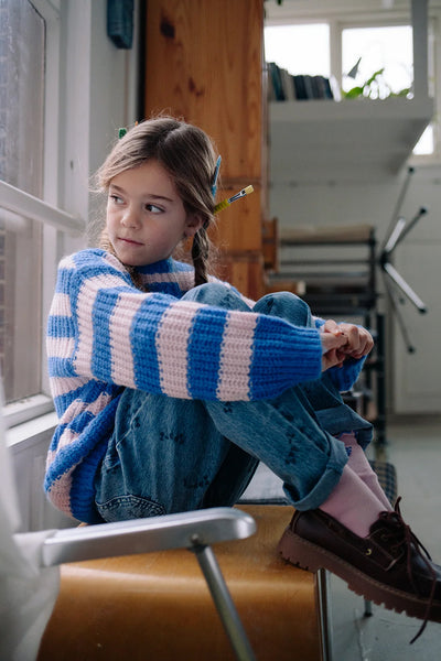 Meisje draagt de gebreide sweater in helder kobaltblauw met lichtroze strepen uit de Club Chaos collectie van Sproet & Sprout.