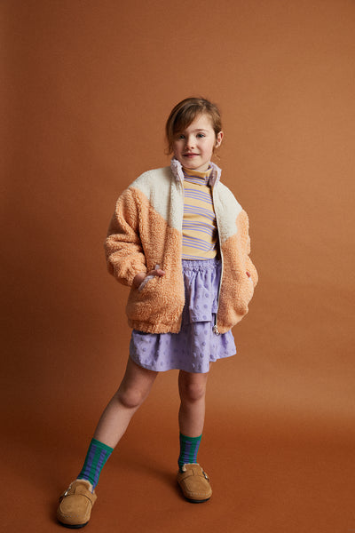 Meisje draagt de teddy colourblock jas in zand uit de Club Chaos collectie van Sproet & Sprout.