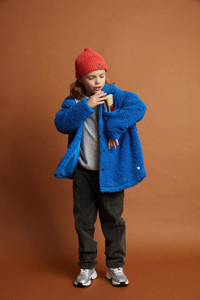 Kind draagt de unisex teddy jas in helder kobaltblauw uit de Club Chaos collectie van Sproet & Sprout.