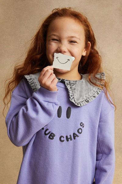 Kind draagt de sweaterjurk in zacht lila met Club Chaos-print uit de Club Chaos collectie van Sproet & Sprout.