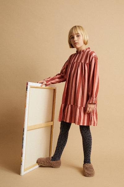 Meisje draagt grijze broekkousen met subtiele animal print van Sproet & Sprout onder een jurk uit de Club Chaos collectie.