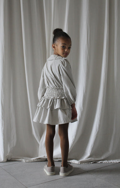 Wit Leonie rokje met zwart vierkantenpatroon van We Are Kids. | Verkrijgbaar bij Little Fashion Addict