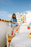 Benedita Dress Denim Chambray van Wander & Wonder met blauwe chambray stof en oranje bloemenborduursel. | Verkrijgbaar bij Little Fashion Addict