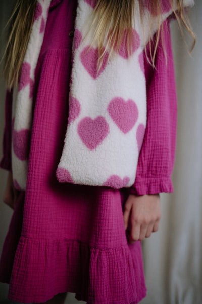 Witte teddy bodywarmer voor meisjes van Daily Brat met roze hartjes, ideaal om te dragen over jurkjes of truien. | Ontdek Daily Brat bij Little Fashion Addict