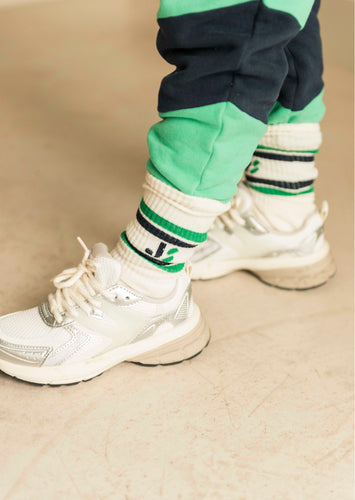 Witte kindersokken met groene en blauwe strepen en Jenest-logo, gedragen met sneakers | JS Sport Socks Off White Green Blue | Verkrijgbaar bij Little Fashion Addict