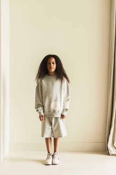 Grijze sweater met witte badgeprint van Jenest – uniseks model voor kids | Verkrijgbaar bij Little Fashion Addict
