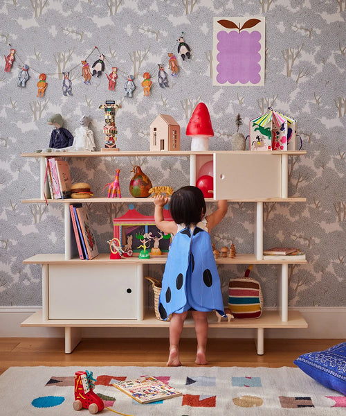 Kind bij de Oeuf NYC Mini Library in wit en berken, gevuld met boeken en speelgoed in een kinderkamer