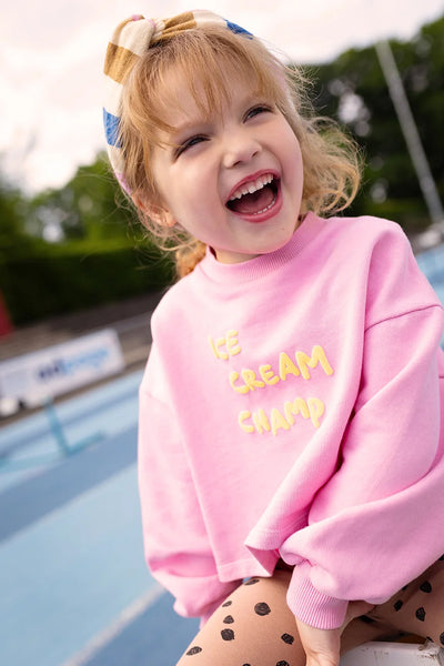 Meisje draagt cropped Ice Cream sweater met batman mouwen van Sproet & Sprout | Uit de Champions League of Fun collectie - Verkrijgbaar bij Little Fashion Addict