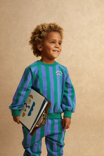 Jongen draagt de gestreepte sweater in Deep Green (diepgroen) en Crayon Cloud (zacht lavendelblauw) uit de Club Chaos collectie van Sproet & Sprout.