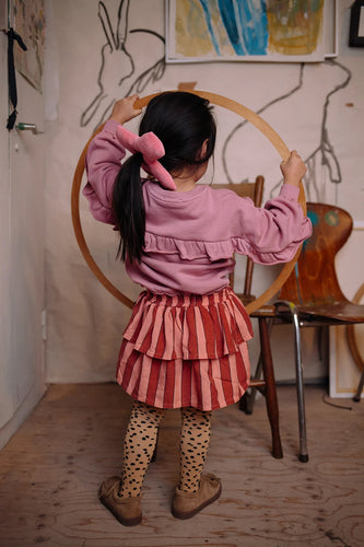 Meisje draagt de zacht oudroze sweater met ruffles op de rug uit de Club Chaos collectie van Sproet & Sprout.