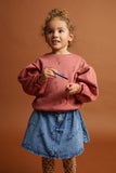 Kind draagt de denim rok met subtiele all-over SPRT-print uit de Club Chaos collectie van Sproet & Sprout.