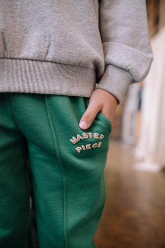 Jongen draagt de diepgroene sweatpants uit de Club Chaos collectie van Sproet & Sprout.