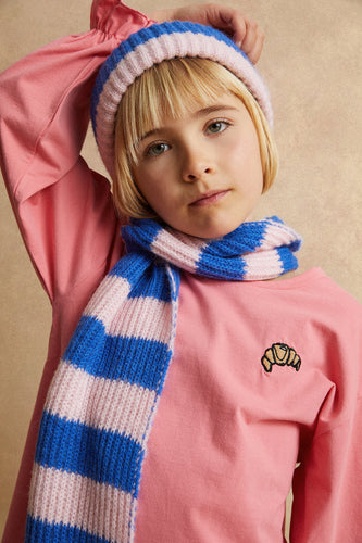 Meisje draagt de gestreepte beanie van Sproet & Sprout met de bijpassende sjaal uit de Club Chaos collectie.