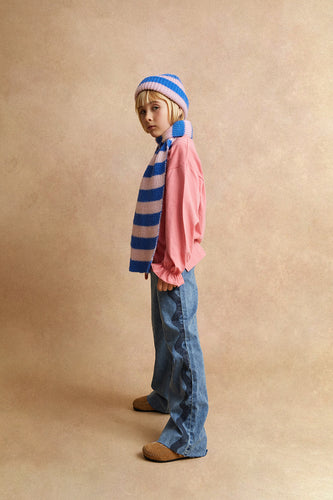 Meisje draagt de gestreepte sjaal en bijpassende beanie van Sproet & Sprout uit de Club Chaos collectie.