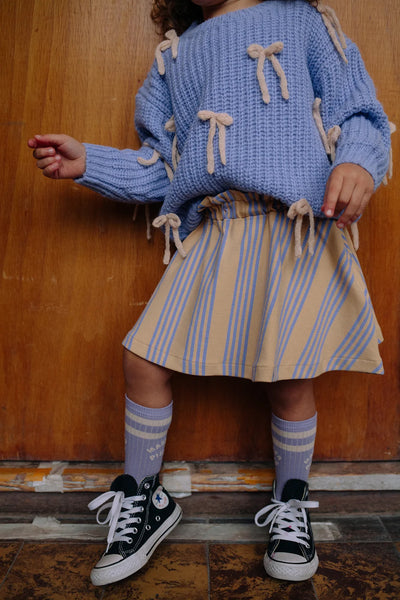 Kind draagt lila kindersokken van Sproet & Sprout onder een rok uit de Club Chaos collectie.